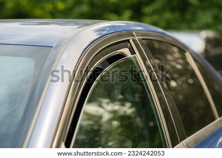 Heat, high temperature concept. Closeup of slightly ajar car window for better cooling on hot summer day. Opened vehicle window for air circulation in warm weather Royalty-Free Stock Photo #2324242053
