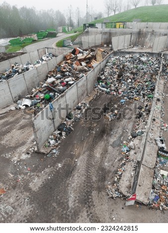 Landfill site, a pile of stinky different junk disposal in the concrete section for unsorted waste materials Royalty-Free Stock Photo #2324242815