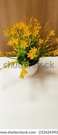 Beautiful multi-colored artificial flower standing on a white surface