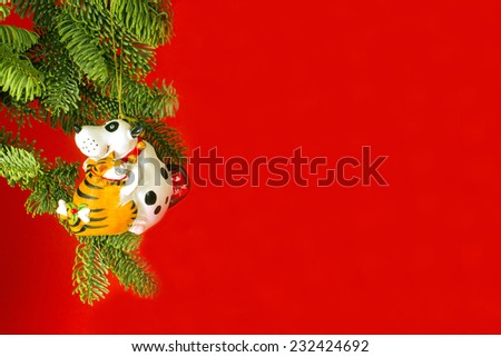 Christmas dog and cat  ornament hanging on Christmas tree branch on a bright red background
