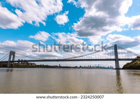 The magnificent clouds gracefully adorned the sky above the Hudson River, framing the iconic George Washington Bridge and accentuating the dazzling New York skyline.
