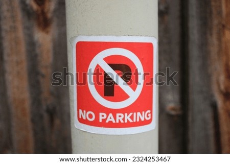 Red No Parking sticker attached to a lamp post
