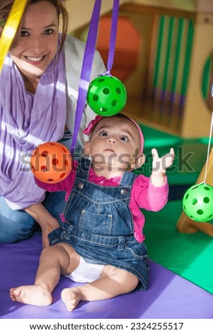 Beautiful ten months baby girl playing with her mom. Early stimulation for toddlers concept. Royalty-Free Stock Photo #2324255517