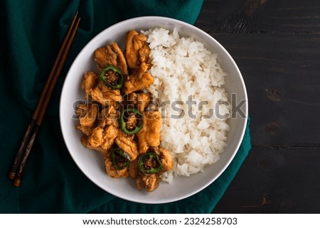 Crispy Hawaiian Garlic Chicken Served with Jasmine Rice: Fried chicken thighs in garlic-soy sauce served with fried jalapeno peppers and white rice Royalty-Free Stock Photo #2324258703