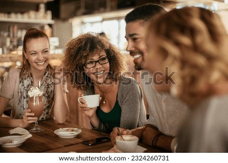 Group of young people enjoying a coffee in a cafe Royalty-Free Stock Photo #2324260731