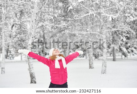 happy girl laughing, enjoying life and throws snow at winter outdoors