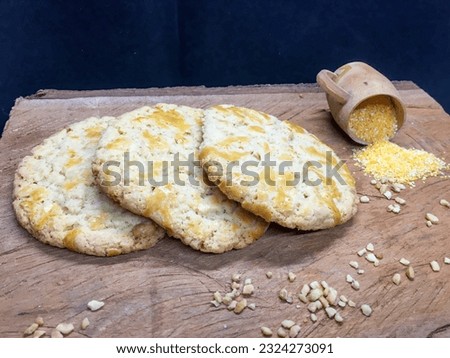 Bakery product, mineira broa or homemade corn bread on a wooden board on a dark background. Traditional Brazilian recipe from the region of Minas Gerais. Typical cerrado food