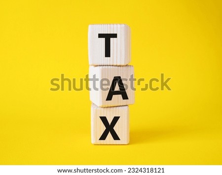 Tax symbol. Wooden cubes with word Tax. Beautiful yellow background. Business and Finace and Tax concept. Copy space.