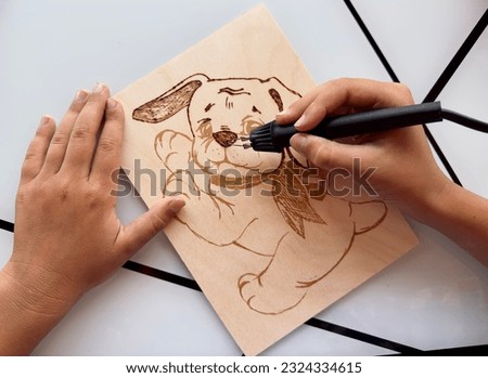 burn the drawing on the board Royalty-Free Stock Photo #2324334615