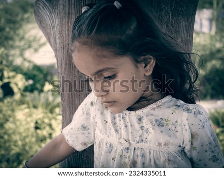 Cute kid girl wearing black and white dresses in park .Blur background of clear focus portrait photo.different face style with different present effect.Street poster and wallpaper images.