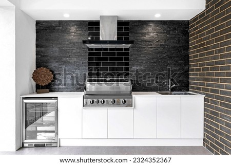Outdoor white kitchen with barbecue, drink fridge and sink