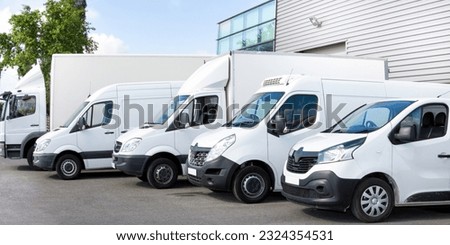 Several cars vans trucks parked in parking lot for shipping delivery Outside of Logistics Distributions Warehouse Royalty-Free Stock Photo #2324354531