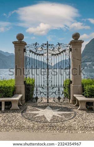 Ancient wrought iron gate overlooking Lake Lugano, Switzerland, in the Ciani park Royalty-Free Stock Photo #2324354967