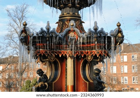 Winter View of Frozen Water on Ornate Victorian Cast Iron Fountain in Public Park in Close Up  Royalty-Free Stock Photo #2324360993