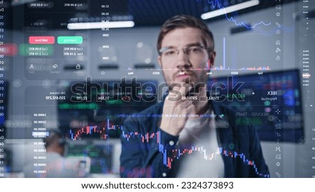 Male financial analyst works in broker agency office. 3D abstract AI graphics of real-time stocks, cryptocurrency charts on glass wall. VFX animation. Computers and big digital screens on background.