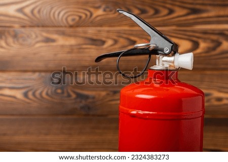Fire extinguisher on a brown wooden background. Fire protection, home fire extinguisher. home security concept. Place for text. Copy space.banner