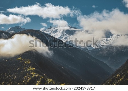Beautiful view of the autumn mountains in Svaneti, Georgia, Snow-capped mountains and blue sky with clouds.