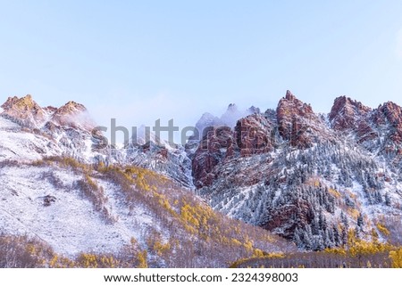 Maroon Bells sunrise in Aspen, Colorado red elk mountains with rocky mountain and snow in late autumn with winter mist fog cloud covering