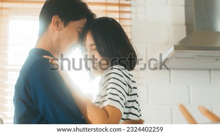 Attractive young Asian couple enjoy their time at home having lovely romantic dance. Happy mature lover showing love and care spend new marriage romance relationship in the kitchen Royalty-Free Stock Photo #2324402259
