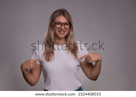 Young happy woman in tshirt on gray background. Mockup for design
