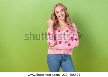 Portrait of charming lady promoter direct finger empty space ad ads adv wear pink shirt cardigan jeans isolated green color background