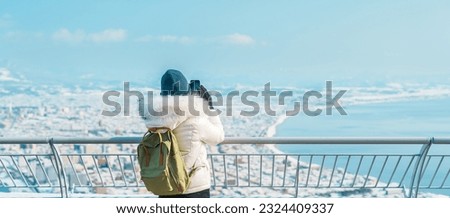 Woman tourist Visiting in Hakodate, Traveler in Sweater sightseeing view from Hakodate mountain with Snow in winter. landmark and popular for attractions in Hokkaido, Japan.Travel and Vacation concept Royalty-Free Stock Photo #2324409337
