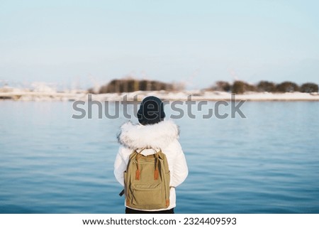 Woman tourist Visiting in Hakodate, Traveler in Sweater sightseeing Hakodate port near Red Brick Warehouse with Snow in winter. Hokkaido, Japan.Travel and Vacation concept Royalty-Free Stock Photo #2324409593