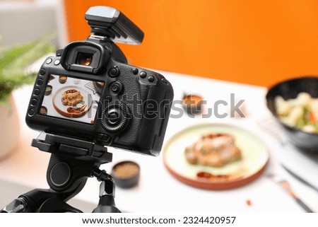 Professional camera with picture of meat medallion on display in photo studio, space for text. Food stylist