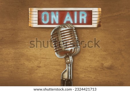 Retro styled image of an authentic vintage microphone with on air illuminated sign