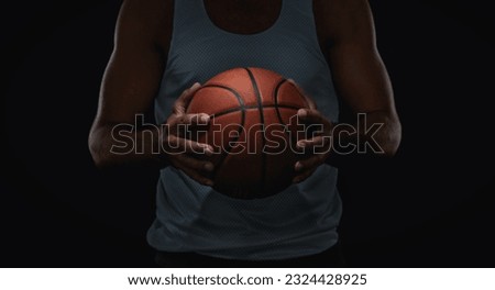 Close up of basketball ball in athlete hands, isolated on black background with copy space Royalty-Free Stock Photo #2324428925