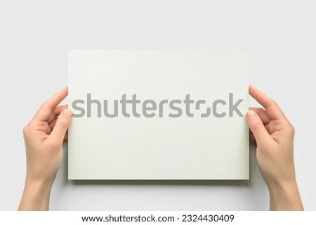 female hands hold empty rectangular cardboard banner on white background. empty space for text Royalty-Free Stock Photo #2324430409