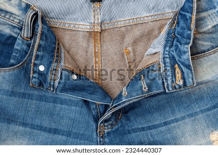Close up of crotch of blue jeans. Texture old blue jean front with seam and crotch of trouser. Royalty-Free Stock Photo #2324440307