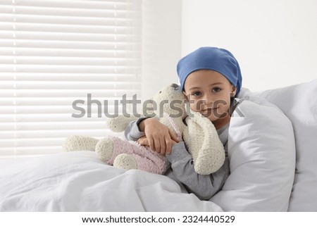 Childhood cancer. Girl with toy bunny in hospital Royalty-Free Stock Photo #2324440529