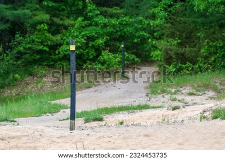 Trail markers showing the way on a sandy trail through the woods Royalty-Free Stock Photo #2324453735