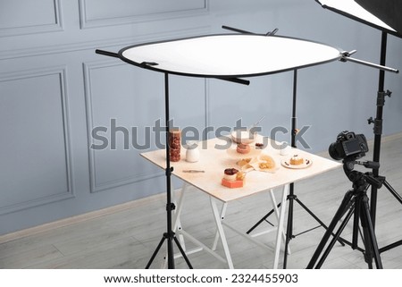 Professional equipment and composition with delicious desserts on wooden table in studio. Food photography