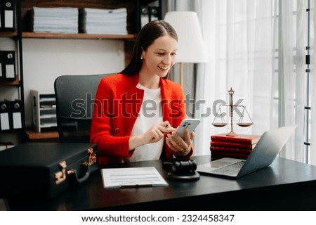 justice and law concept. Female judge in a courtroom  the gavel, working with smart phone and laptop and digital tablet computer on black  table in morning light 
