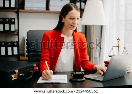justice and law concept. Female judge in a courtroom  the gavel, working with smart phone and laptop and digital tablet computer on black  table in morning light 