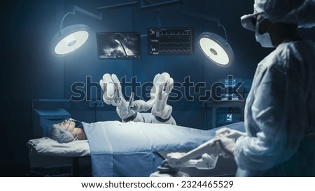 Surgeon Wearing Augmented Reality Headset And Using High-Precision Remote Controlled Robot Arms To Operate On Patient In Hospital. Doctor Working With Futuristic Robotic Limbs And Monitors With Vitals Royalty-Free Stock Photo #2324465529