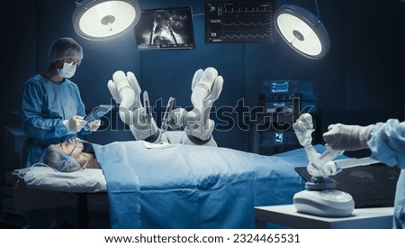 Surgeon Wearing AR Headset, Using High-Precision Remote Controlled Robot Arms To Operate On Patient, While His Colleague Checking Vitals On Tablet In Hospital. Doctors Working With Robotic Limbs. Royalty-Free Stock Photo #2324465531