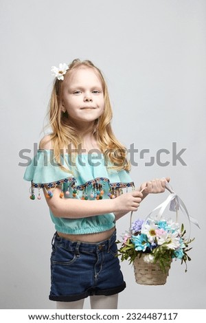 Portrait of a happy little girl with long light hair, fresh flowers in a basket, capturing the essence of childhood innocence and joy