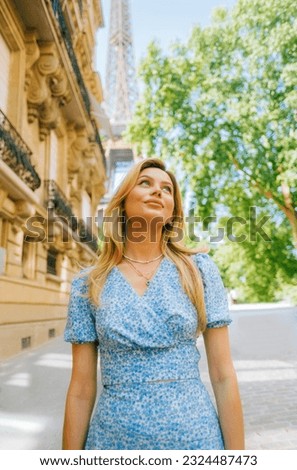 Portrait of young attractive woman fashion model posing near Eiffel Tower in Paris .