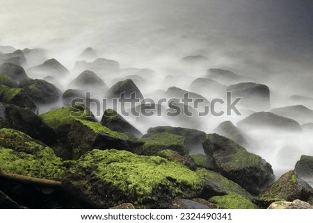 Kochi, Kerala, India-October 6 2022; A Classis Long exposure picture in Motion blur of a sea shore with the water waves hitting against the rocks in the coastal Kochi of India.