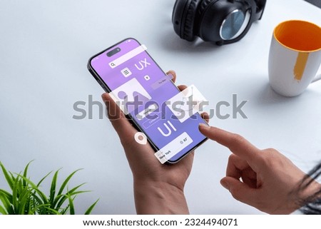 Process of creating an interface for a mobile app. User interface and experience concept. Modern app on smart phone in woman hands Royalty-Free Stock Photo #2324494071