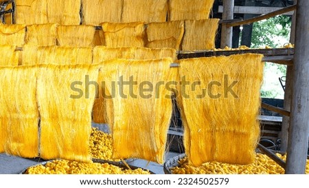 spinning golden silk threads, silkworms. Royalty-Free Stock Photo #2324502579