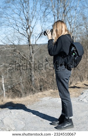 Attractive female outdoor photographer holding a camera