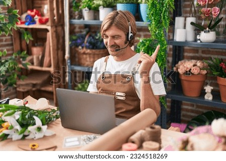 Caucasian man with mustache working at florist shop doing video call smiling happy pointing with hand and finger to the side 