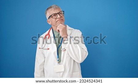 Middle age grey-haired man doctor standing with doubt expression over isolated blue background
