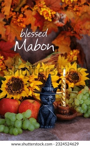 black cat figurine, fruits, sunflowers and candle on table, abstract background. Blessed Mabon greeting card. witch altar. witchcraft, Magic, esoteric ritual for autumn wiccan holiday.
