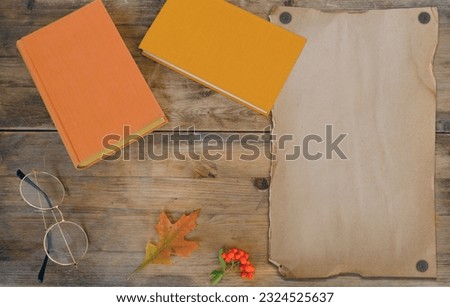 empty blank space, mock up of old paper, Autumn rustic wooden table with books, fallen yellow, orange leaves and berries, concept outdoor party, good weather, cozy autumn mood