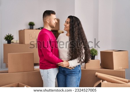 Man and woman couple hugging each other standing at new home